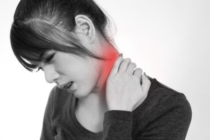 Young woman holding neck in pain and discomfort